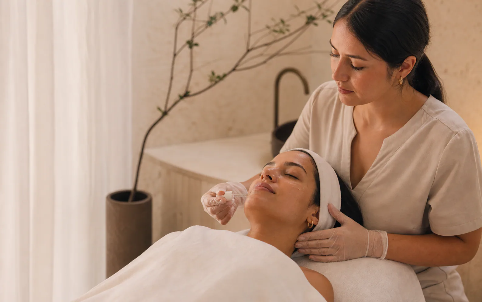 Profesional realizando un tratamiento facial de referencia